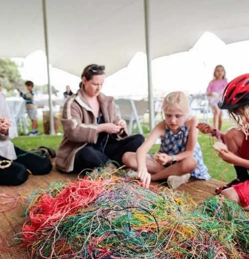 A group of people weaving.