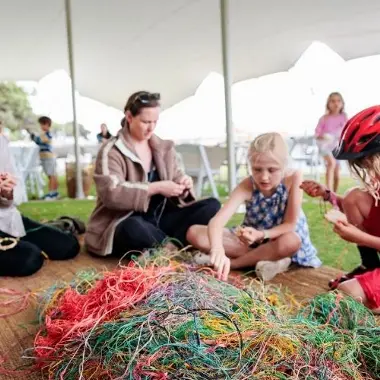 A group of people weaving.