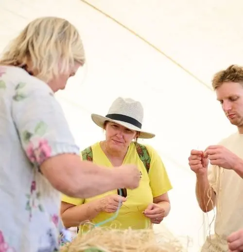 Sharyn Egan instructing a group of people on how to weave using traditional Aboriginal methods.