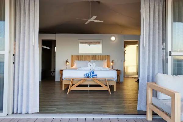 A queen bed in the middle of the room.