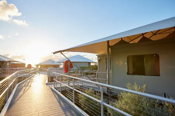 The boardwalk between the tents with the sun rising.