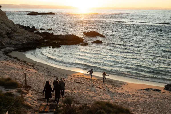 A family running down to the beach to watch sunset