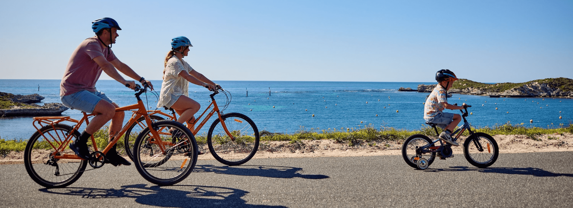 Family cycling past Geordie Bay