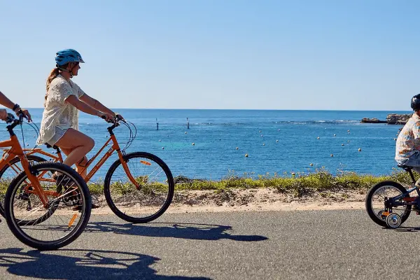 Family cycling past Geordie Bay