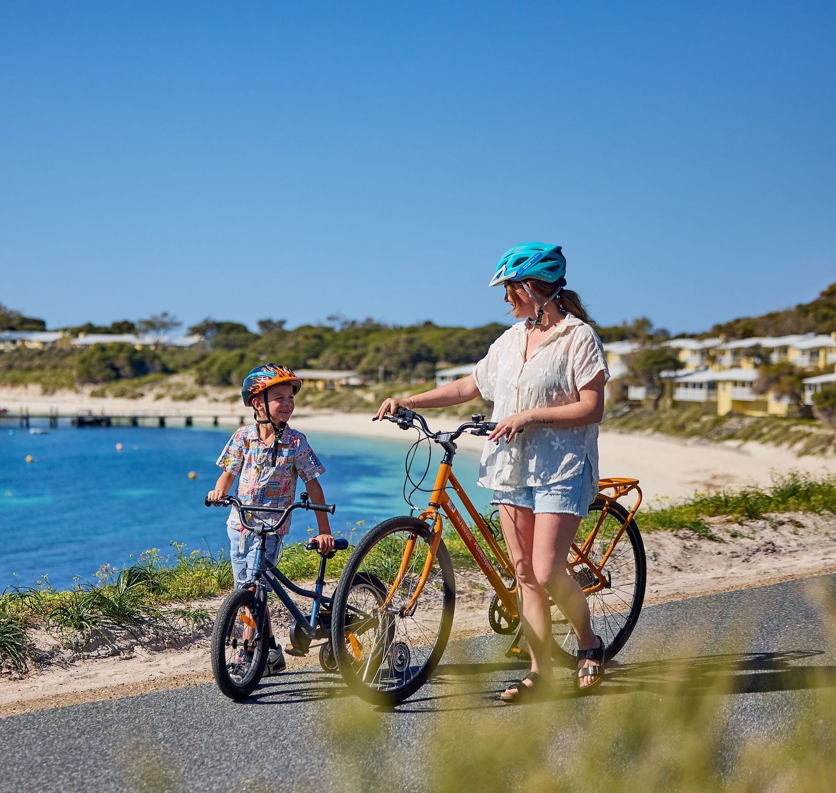 Mother and son with bikes at Geordie Bay on Rottnest Island.