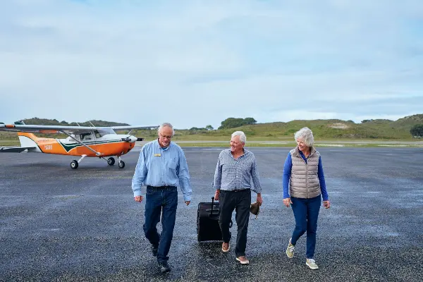 A group of people walking off the tarmac.