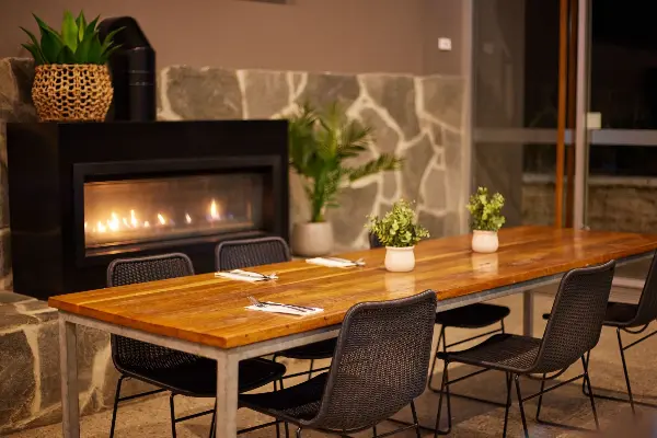 A long table in front of a fireplace at Hotel Rottnest.