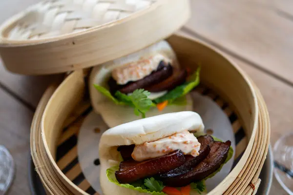 two bao buns in a steamer.