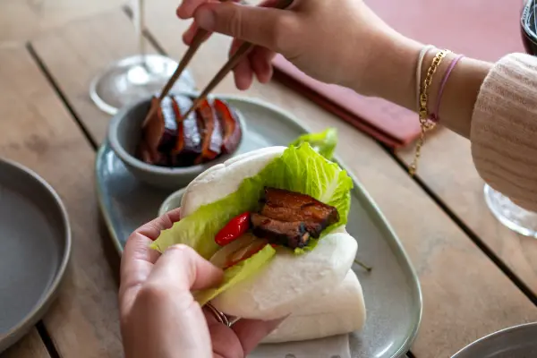 Someone filling a bao bun.