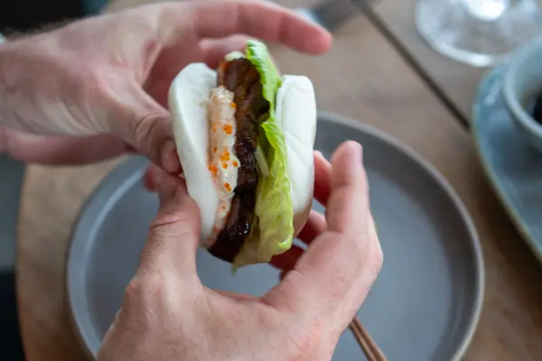 A man holding a bao bun.