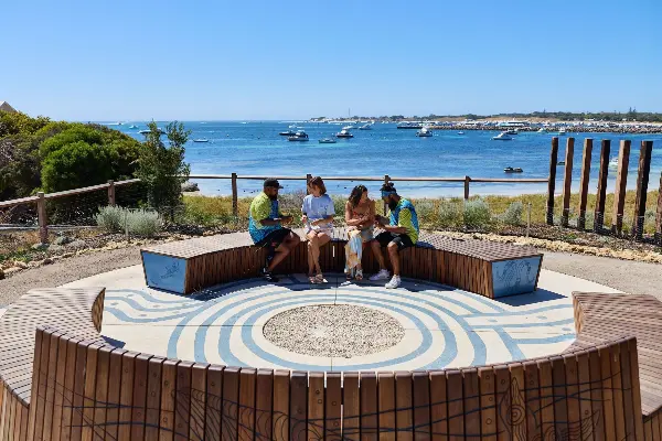 Group sat together with the ocean behind them
