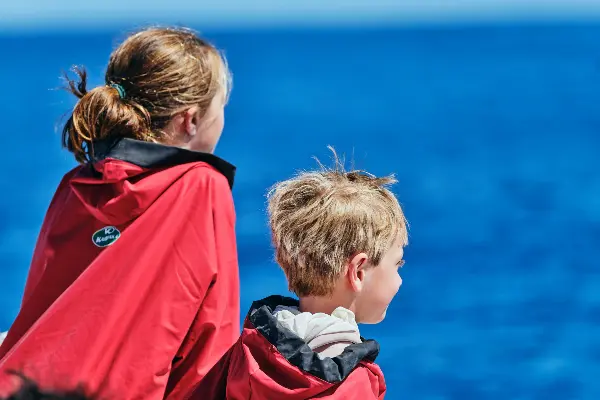Two kids looking at the ocean from a boat.