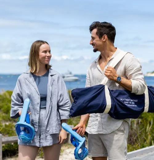 Couple heading to the beach with gear from Rottnest Rentals.
