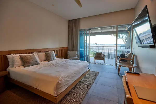 A queen bed with a tv and balcony.