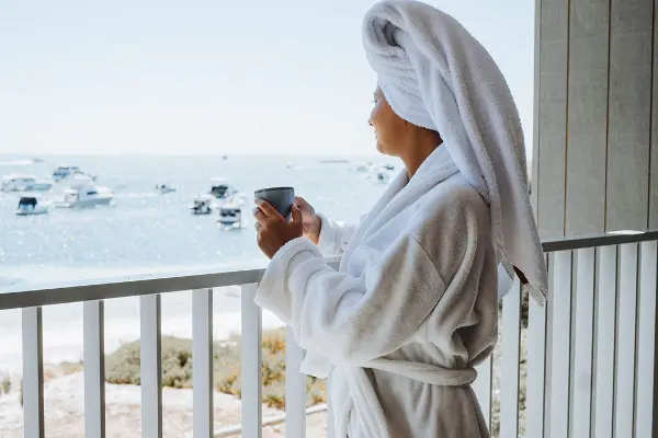 A woman holding a mug on a balcony.