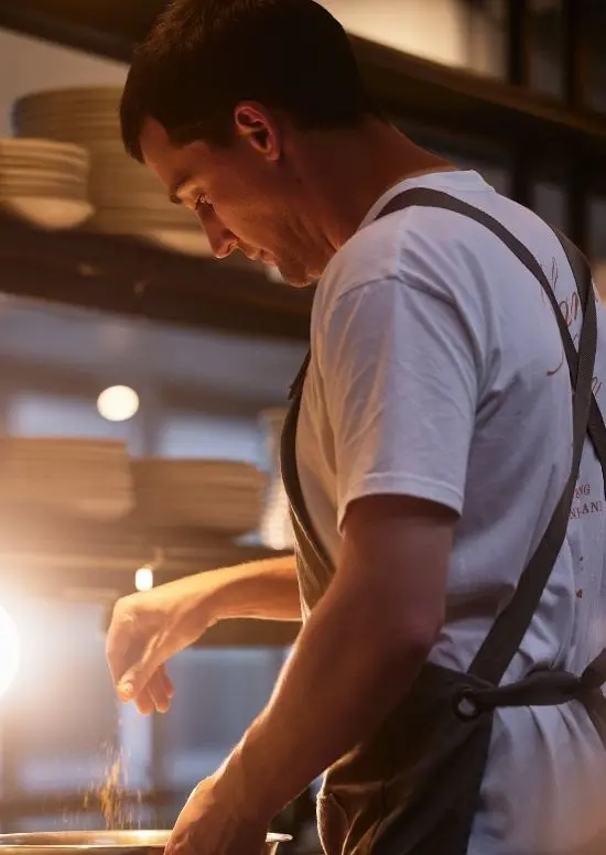 Chef adding seasoning in a bowl
