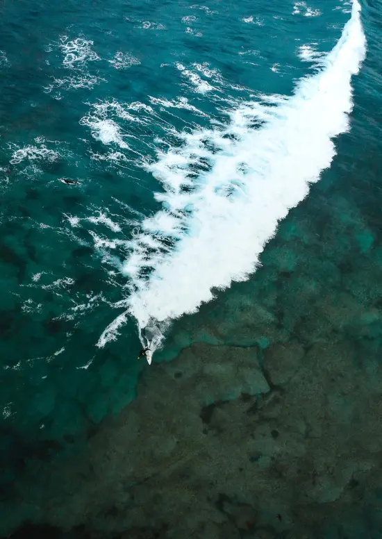 Drone image of a surfer on a wave