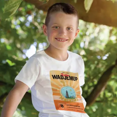 Child sitting in tree wearing travelling t-shirt design