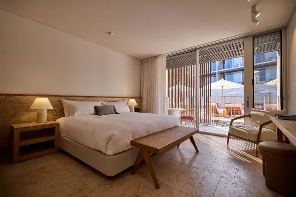 A queen bed with a bench at the end.