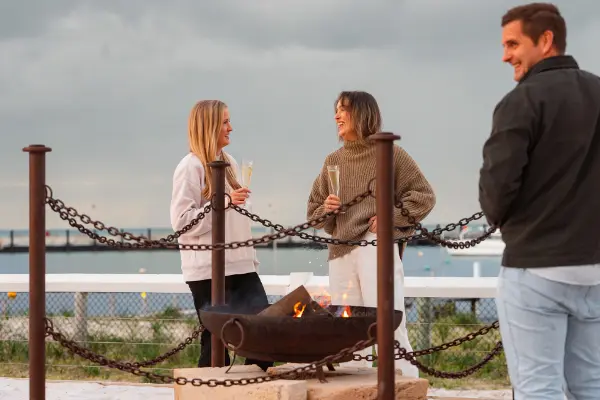 Three people around a firepit